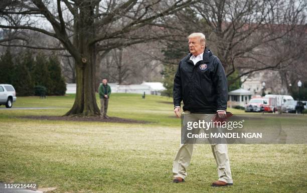President Donald Trump waits for his family to join him to board Marine One before departing from the South Lawn of the White House on March 8, 2019...