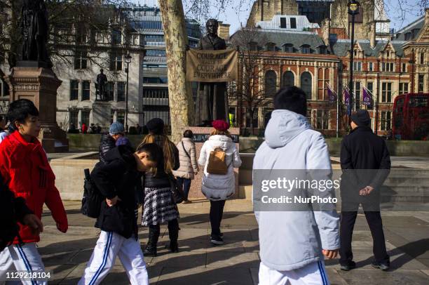 People stop and take pictures to the Statue of Millicent Garrett Fawcett is pictured in Parliament Square, London on March 8, 2019. Dame Millicent...