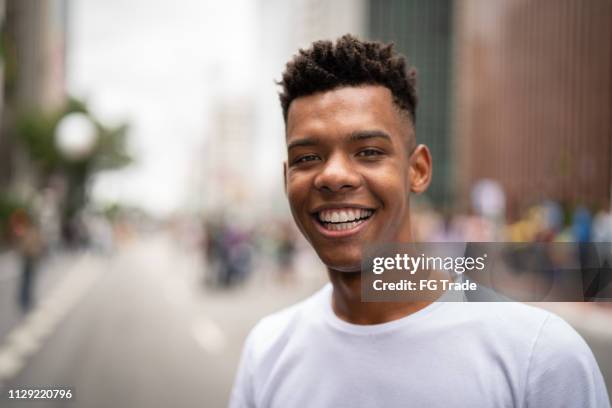 jeune homme latinx afro dans le portrait de la ville - rue 21 photos et images de collection