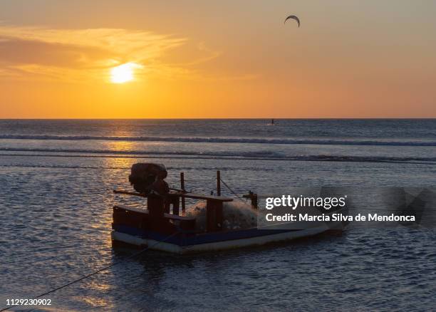 the small fishing boat is ready to go out to sea, during sunset in jericoacoara beach. - na margem de stock pictures, royalty-free photos & images