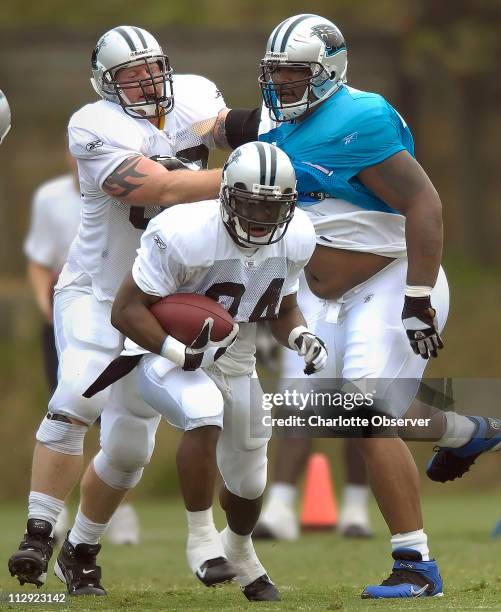 Carolina Panthers running back DeAngelo Williams looks for running room as guard Mike Wahle blocks defensive tackle Kris Jenkins during training camp...