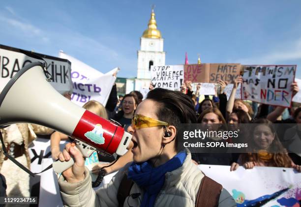 Protester seen chanting slogans on a megaphone during the protest. Ukrainian feminists and their supporters held their march demanding for rights of...
