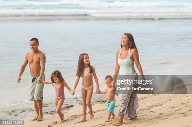 eurasische mama und papa spaziergang am strand mit ihren drei kindern - fat guy on beach stock-fotos und bilder