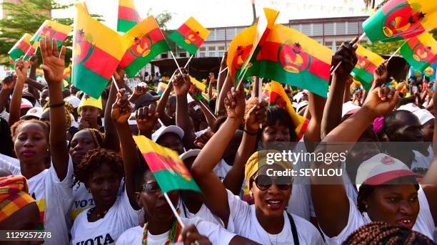 Supporters of the 'Mouvement pour l'alternance democratique' wave flags on March 8, 2019 in Bissau as they attend the closing meeting of the party's...