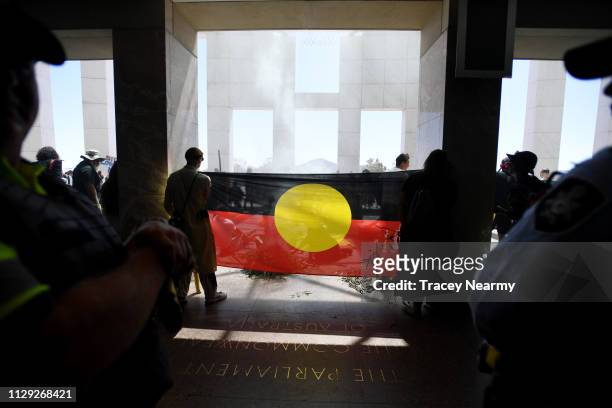 Aboriginal and Torres Strait Islander people, alongside non-Indigenous allies, occupy the foyer and front entry of Parliament House on February 13,...