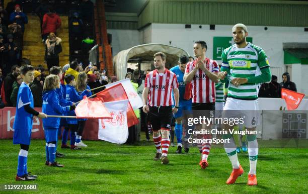 Year-old Alex Newbold walks out onto the pitch with Lincoln City's Jason Shackell after being made one of the mascots for the evening as a surprise...