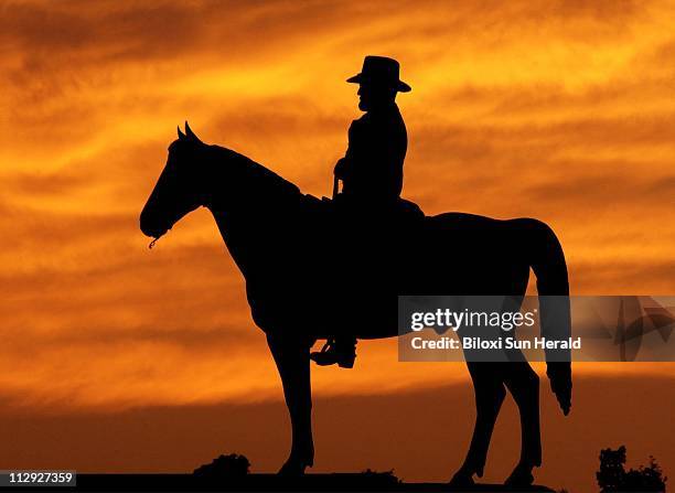 The setting sun silhouettes the statue of Union general Ulysses S. Grant at the Vicksburg National Military Park, as illustrated from one of Tim...