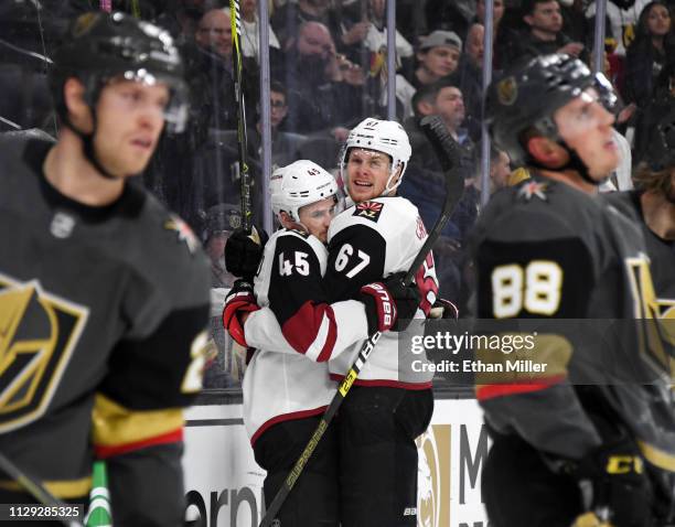 Josh Archibald and Lawson Crouse of the Arizona Coyotes celebrate after Crouse assisted Archibald on a third-period goal against the Vegas Golden...