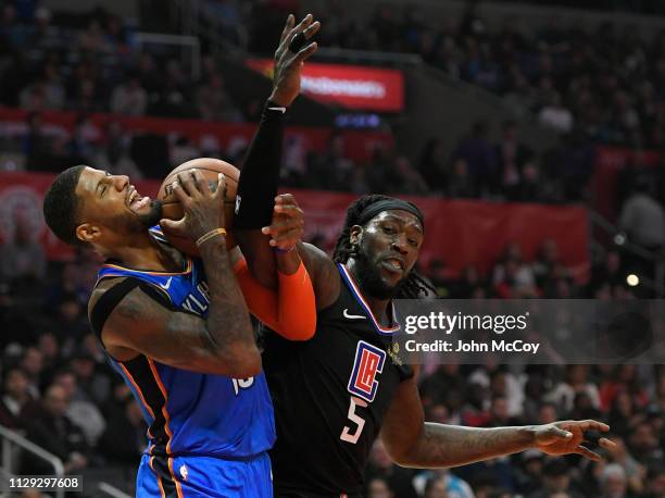 Paul George of the Oklahoma City Thunder is fouled by Montrezl Harrell of the Los Angeles Clippers in the first half at Staples Center on March 8,...