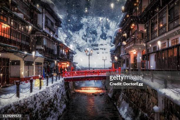 ginzan onsen with snow falling in winter, yamagata, japan - tohoku stockfoto's en -beelden