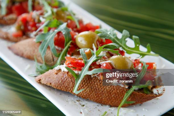 bruschetti con ricotta, pomodoro e olive - bruschetta foto e immagini stock