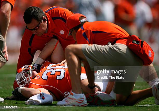 Clemson freshman fullback Chad Diehl is tended to by trainer Jerome Razinski, left, and head trainer Danny Poole after seriously injuring his right...