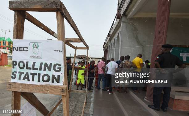 Voters form a queue at a polling station in Port Harcourt, Rivers State, on March 9 as voting has started to elect governors and lawmakers in 29 of...