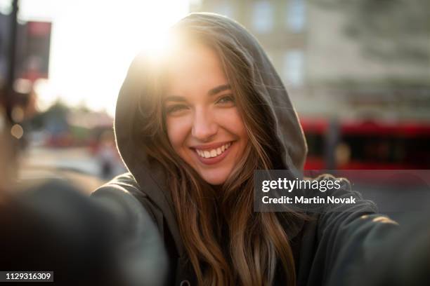 pretty woman taking photo with sun in background - female hipster stock pictures, royalty-free photos & images