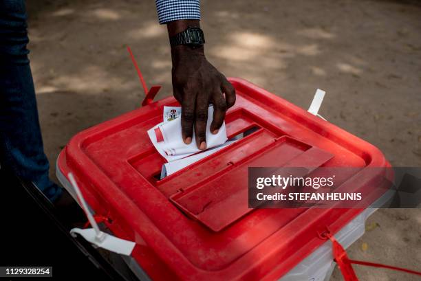 Man places his ballot paper in a ballot box at polling unit in Lagos on March 9, 2019. Nigerians are voting for a second time in a fortnight in...