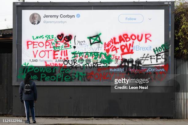 Man walks past a defaced poster from the pro-remain group "Led By Donkeys", featuring a blank tweet by Labour Party leader Jeremy Corbyn and the...