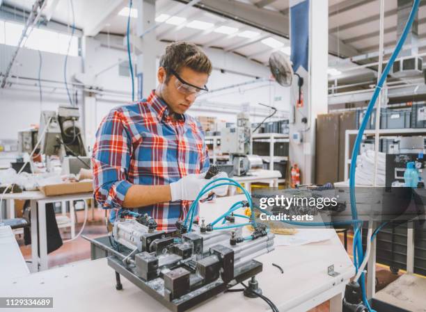 manual worker man working at manufacturing factory - vestido adornado imagens e fotografias de stock