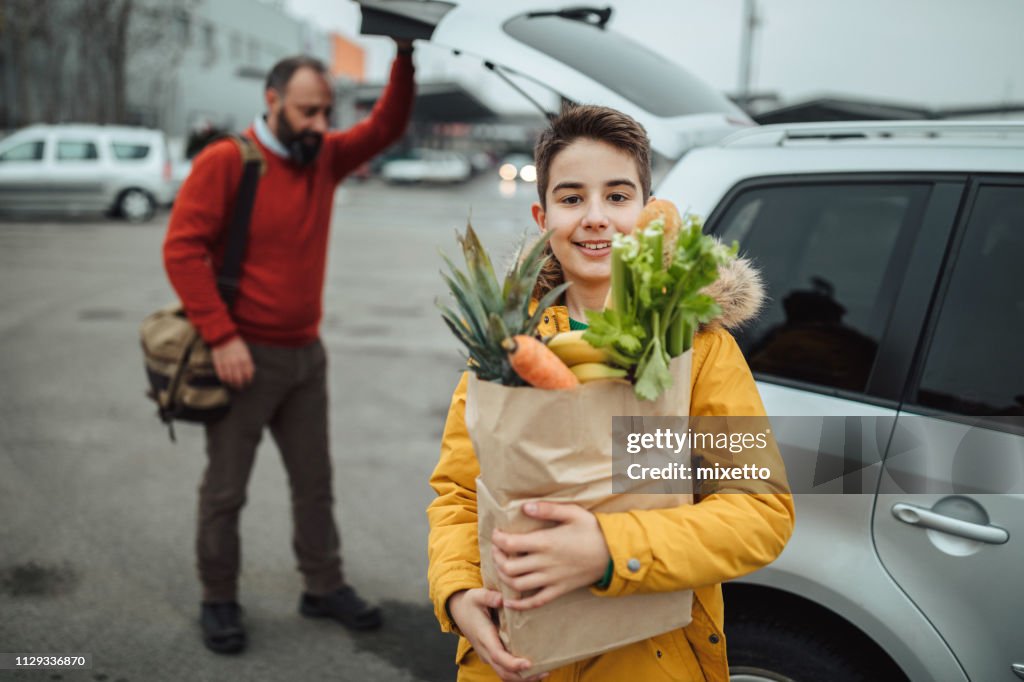 Jongen en zijn vader na de boodschappen te doen