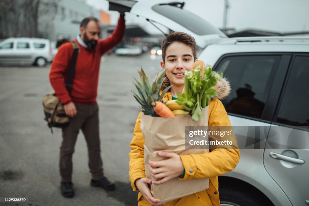 Boy and his father after grocery shopping