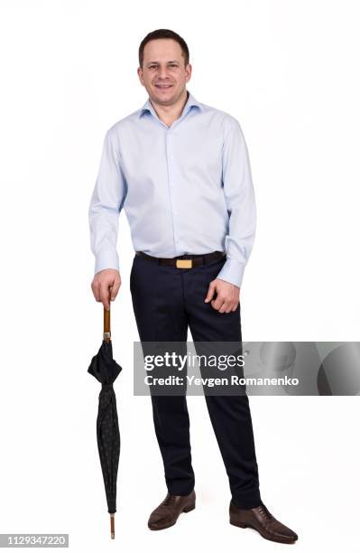 full length portrait of young prosperous businessman dressed in shirt and trousers standing on a white background with closed umbrella - man full body isolated stock pictures, royalty-free photos & images