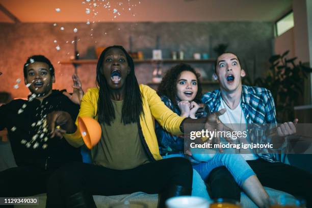 sorprendido amigos viendo película de terror - escandalo tv fotografías e imágenes de stock