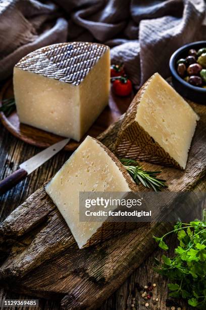 comida española: trozos de queso manchego en la rústica mesa de madera - queso manchego fotografías e imágenes de stock