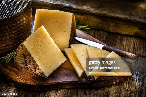 comida española: queso manchego en la rústica mesa de madera - queso manchego fotografías e imágenes de stock