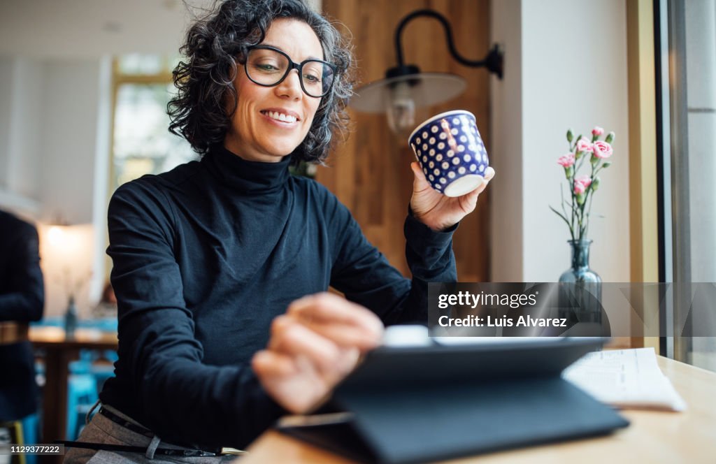 Woman at cafe using digital tablet at coffee shop