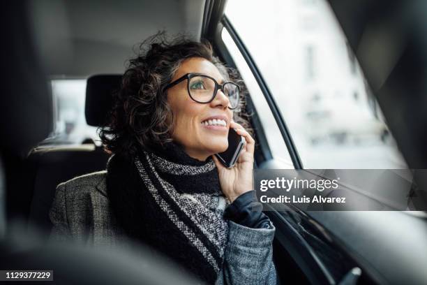 mature woman talking on phone during commute - businesswoman talking smartphone stock pictures, royalty-free photos & images