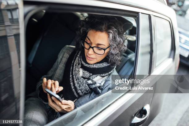 businesswoman testing while traveling by a car - management car smartphone stock-fotos und bilder