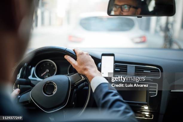 businessman driving the car - mobile phone in hand driving stock pictures, royalty-free photos & images