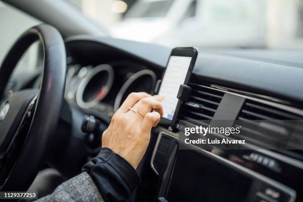 woman using gps navigation in a car - cuadro de instrumentos fotografías e imágenes de stock