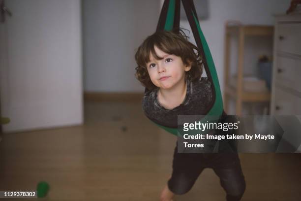 Toddler playing in the swing at home
