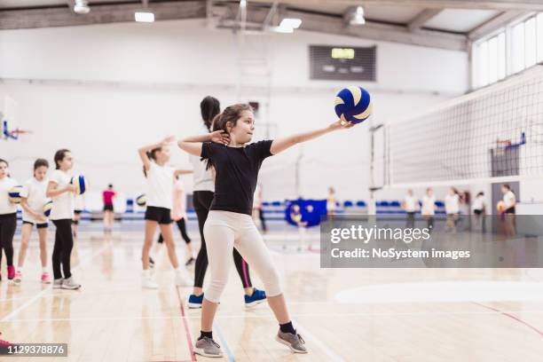 female volleyball team exercising indoors - candid volleyball stock pictures, royalty-free photos & images