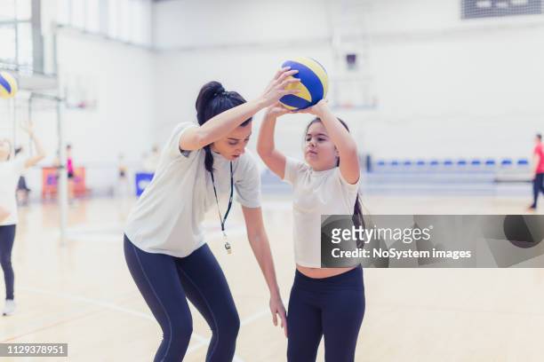 vrouwelijk volleybal team trainen met coach - zaalvolleybal stockfoto's en -beelden