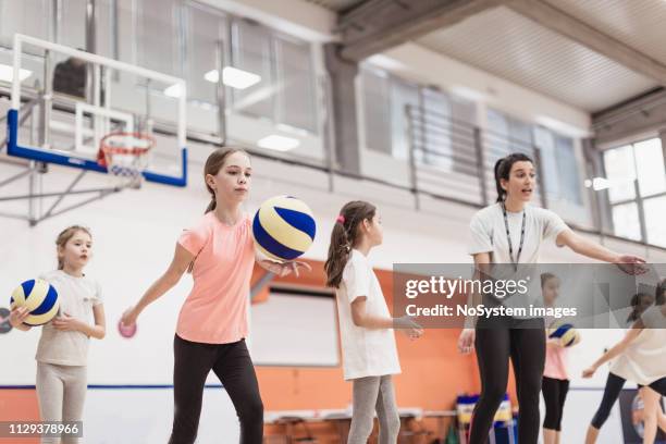 female coach talking with girls at volleyball court - candid volleyball stock pictures, royalty-free photos & images