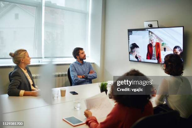 business people having a video call - conference room screens stock pictures, royalty-free photos & images