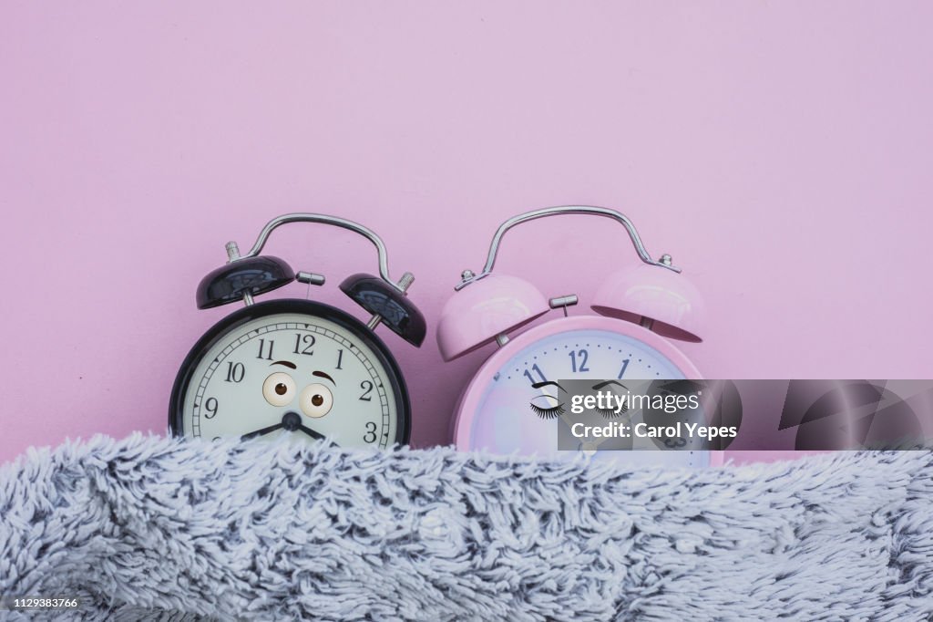 Alarm clock female and male sleeping in bed