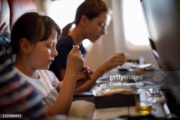 passagiere mit mittagessen während der reise mit dem flugzeug - airplane tray stock-fotos und bilder