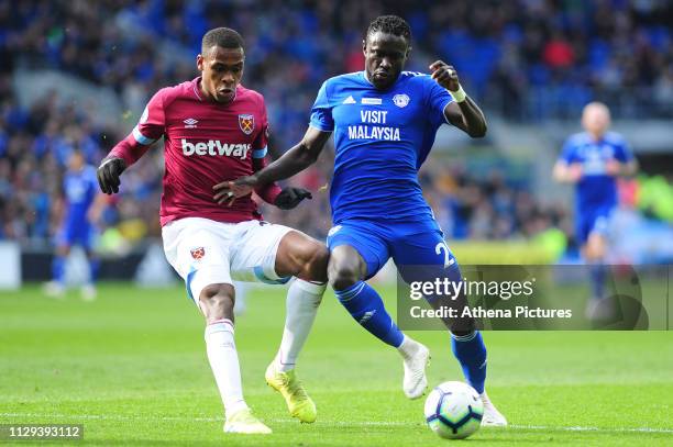 Issa Diop of West Ham United vies for possession with Oumar Niasse of Cardiff City during the Premier League match between Cardiff City and West Ham...