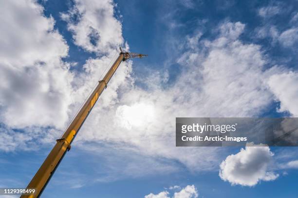 construction crane, blue skies with clouds. - sollevare foto e immagini stock