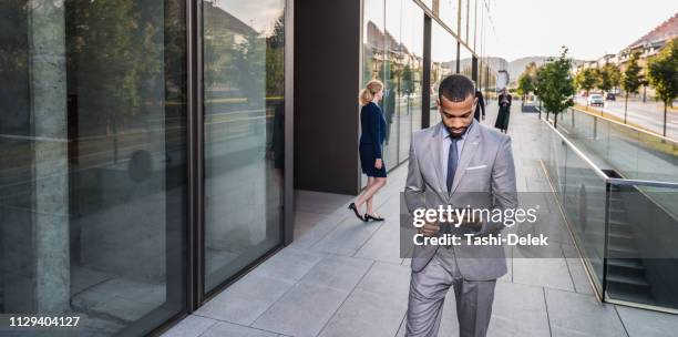 businessman walking outside with digital tablet - man lady phone ipad outside stock pictures, royalty-free photos & images