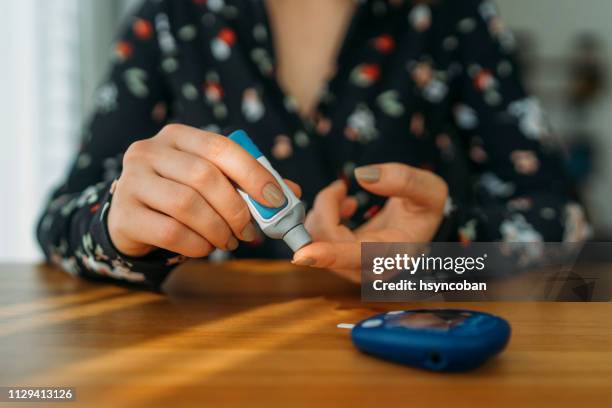 diabetes doing blood glucose measurement - blood sugar test stock pictures, royalty-free photos & images