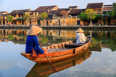 Vietnamese women paddling in old town in Hoi An city, Vietnam