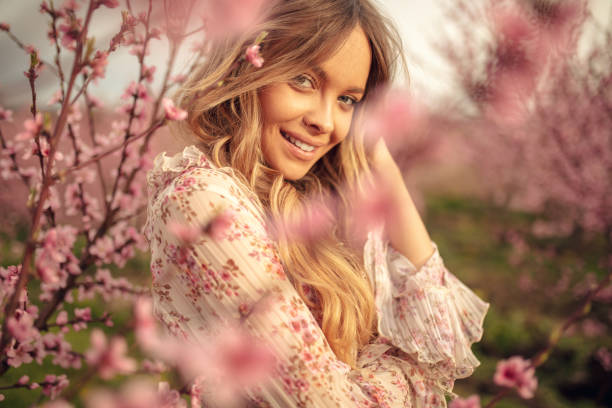 amazing young woman posing in apricot tree orchard at spring - mulher bonita imagens e fotografias de stock