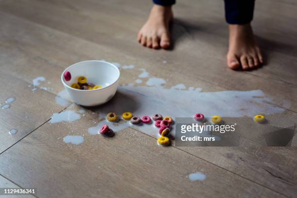 spilled bowl of milk and cereal - derramar actividad fotografías e imágenes de stock