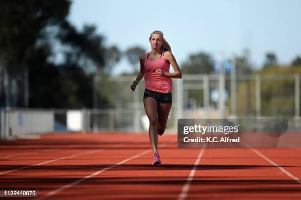 a female athlete runs on a track - jogging track stock pictures, royalty-free photos & images