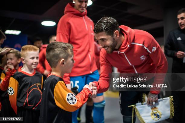 Sergio Ramos of Madrid talks to a escort kids in the players tunnel prior to the UEFA Champions League Round of 16 First Leg match between Ajax and...