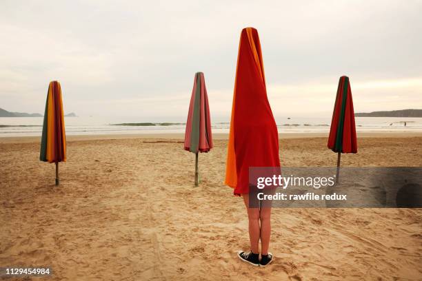 surreal beach scene - parasols stockfoto's en -beelden