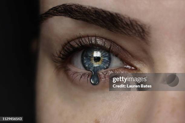 eye iris turning into tear drop - träne stock-fotos und bilder